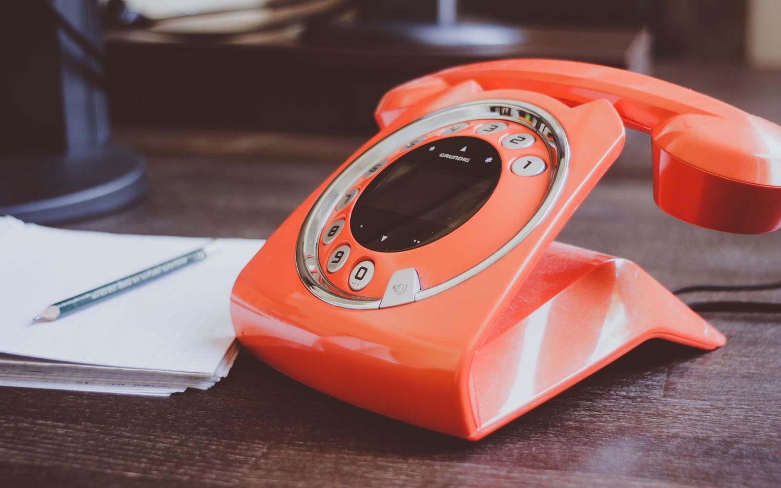 A red telephone on a desk